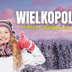Uśmiechnięta dziewczynka w zimowym stroju pokazuje kciuki w górę na tle ośnieżonych drzew. Wielkopolska oferuje wspaniałe atrakcje dla dzieci na zimę!