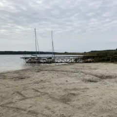 Plaża nad jeziorem powidzkim z pomostem, dwoma żaglówkami i zjeżdżalnią. Idealne miejsce na wodne atrakcje.