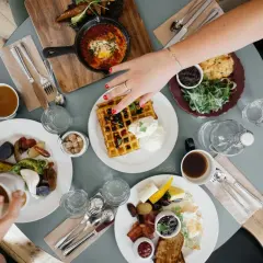 Pyszne śniadanie na stole, idealne miejsce, gdzie dobrze i tanio zjeść w Rzeszowie. Wafle, jajka sadzone, warzywa i kawa.