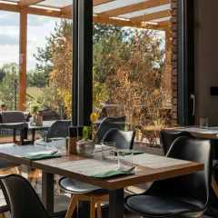 Stolik w restauracji z widokiem na ogród. Idealne miejsce na romantyczną kolację. Polecane restauracje Poznań.