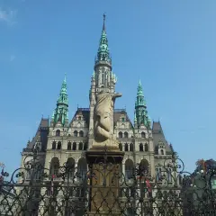 Imponująca budowla z wieżami i rzeźbą na pierwszym planie. Jedna z wielu atrakcji Liberec, która zachwyca turystów.