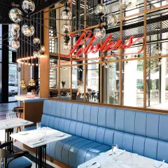 Eleganckie restauracje w Warszawie z niebieskimi kanapami i neonowym napisem "Lobsters".