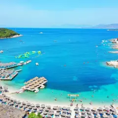 Rajskie albania plaże z turkusową wodą, leżakami i pływającymi atrakcjami. Idealne miejsce na wakacje.