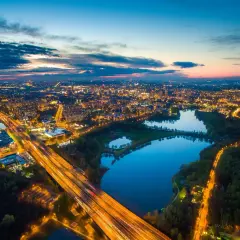 Zachód słońca nad miastem, gdzie autostrada przecina park z trzema stawami w Katowicach.