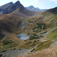 Malownicze Tatry oferują wspaniałe atrakcje. Widok na górskie jezioro i strome zbocza zachwyca.