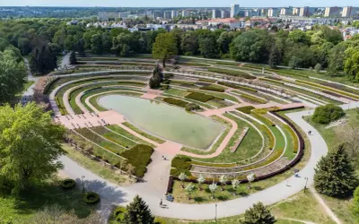 Widok z lotu ptaka na park cytadela z jeziorem, tarasami i alejkami. W tle widać miasto.
