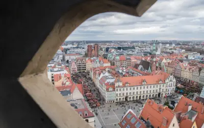 Widok z wieży widokowej we Wrocławiu na Rynek i Ostrów Tumski. Widać kolorowe kamienice, targ i katedrę.