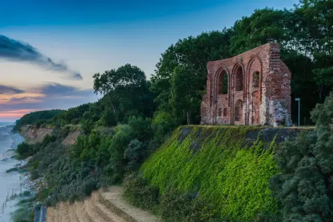 Ruiny kościoła na klifie nad morzem, porośnięte zielenią. Niezwykłe trzęsacz atrakcje przyrodnicze i historyczne.