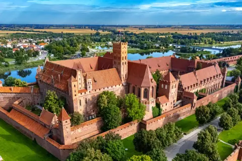Zamek w Malborku, jedna z największych atrakcji Żuław Wiślanych, majestatycznie wznosi się nad rzeką Nogat.