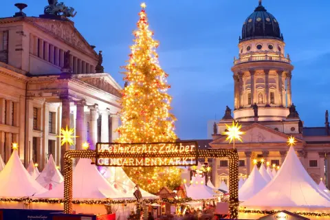 Jarmark Gendarmenmarkt w Berlinie, jeden z najpiękniejszych jarmarków bożonarodzeniowych w Europie, z choinką i kopułą kościoła w tle.