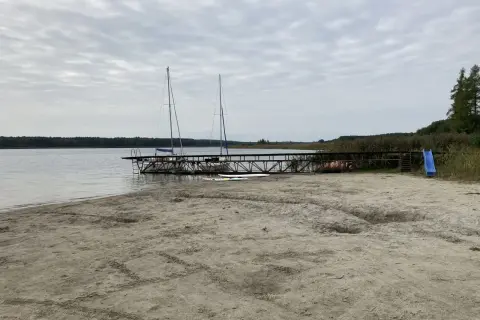 Plaża nad jeziorem powidzkim z pomostem, dwoma żaglówkami i zjeżdżalnią. Idealne miejsce na wodne atrakcje.