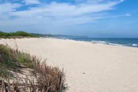 Plaża we Władysławowie, idealne miejsce na wypoczynek. Piasek, morze i zielone wydmy tworzą piękne krajobrazy, a liczne atrakcje czekają na turystów.