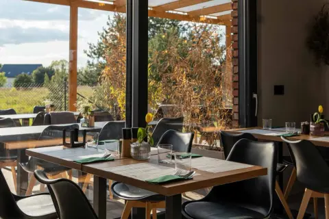 Stolik w restauracji z widokiem na ogród. Idealne miejsce na romantyczną kolację. Polecane restauracje Poznań.