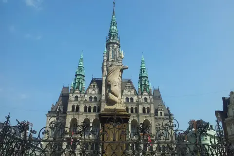 Imponująca budowla z wieżami i rzeźbą na pierwszym planie. Jedna z wielu atrakcji Liberec, która zachwyca turystów.