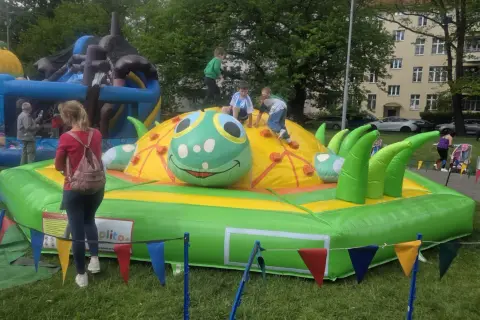 Dzieci bawią się na dmuchanej gąsienicy, jednej z wielu atrakcji na dzień dziecka.
