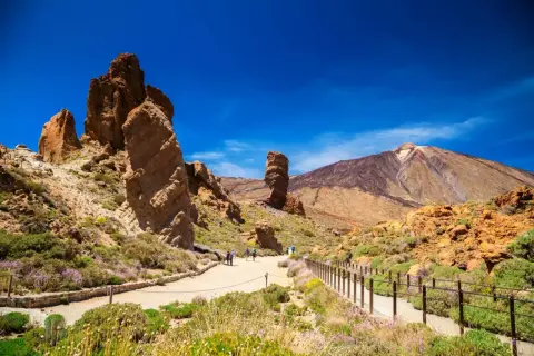 Wędrówka po wulkanicznym krajobrazie Teneryfy na własną rękę. Monumentalne skały i majestatyczny Teide pod błękitnym niebem.