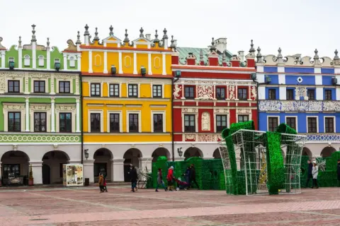 Kolorowe kamienice na Rynku w Zamościu, znane z unikatowych zdobień, tworzą malownicze tło dla świątecznej instalacji w kształcie prezentu.