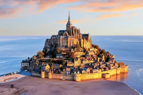 Mont Saint-Michel, jeden z najpiękniejszych zabytków Francji, majestatycznie wznosi się na wyspie otoczonej wodą.