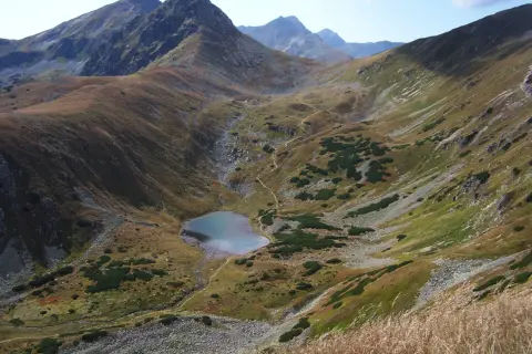 Malownicze Tatry oferują wspaniałe atrakcje. Widok na górskie jezioro i strome zbocza zachwyca.