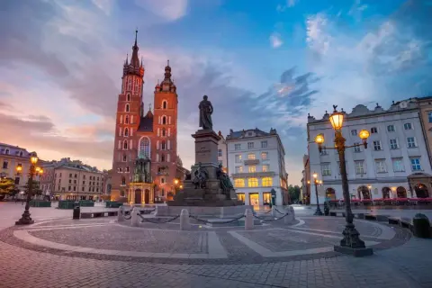 Zachód słońca na Rynku Głównym w Krakowie. Spacer po Rynku, zwiedzanie Sukiennic i Kościoła Mariackiego to tylko część tego, co można robić w Krakowie.