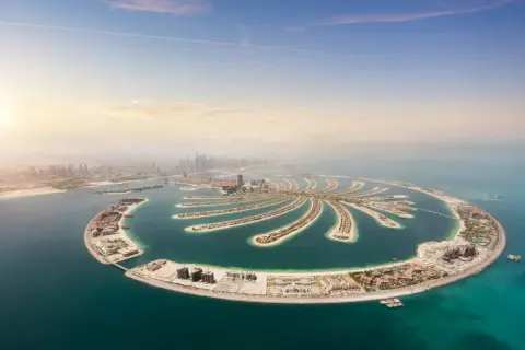 Palm Jumeirah, ikona Dubaju, to jedno z miejsc, które trzeba zobaczyć. Sztuczna wyspa w kształcie palmy oferuje luksusowe hotele i wille.