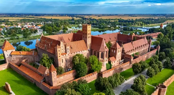 Zamek w Malborku, jedna z największych atrakcji Żuław Wiślanych, majestatycznie wznosi się nad rzeką Nogat.
