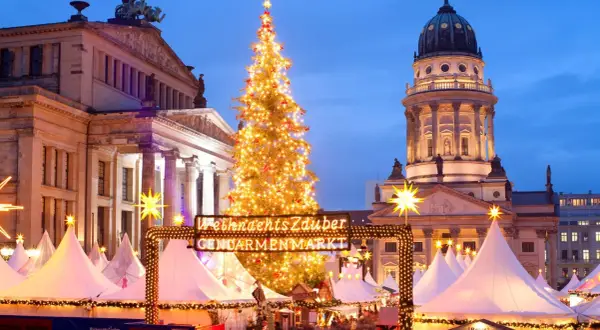 Jarmark Gendarmenmarkt w Berlinie, jeden z najpiękniejszych jarmarków bożonarodzeniowych w Europie, z choinką i kopułą kościoła w tle.