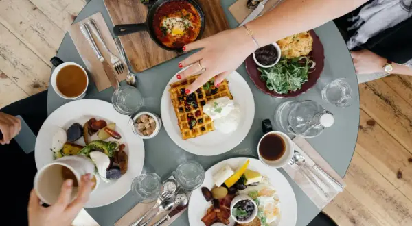 Pyszne śniadanie na stole, idealne miejsce, gdzie dobrze i tanio zjeść w Rzeszowie. Wafle, jajka sadzone, warzywa i kawa.