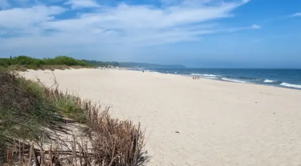 Plaża we Władysławowie, idealne miejsce na wypoczynek. Piasek, morze i zielone wydmy tworzą piękne krajobrazy, a liczne atrakcje czekają na turystów.