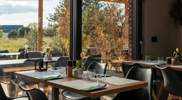 Stolik w restauracji z widokiem na ogród. Idealne miejsce na romantyczną kolację. Polecane restauracje Poznań.