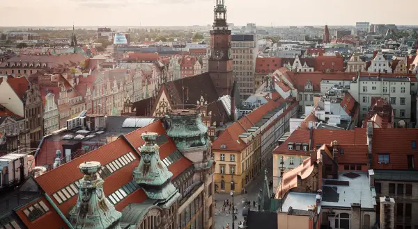 Widok na wrocławskie kamienice i wieżę ratuszową. Odkryj wrocław atrakcje, spacerując po urokliwych uliczkach.