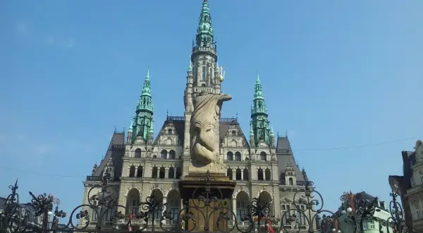Imponująca budowla z wieżami i rzeźbą na pierwszym planie. Jedna z wielu atrakcji Liberec, która zachwyca turystów.