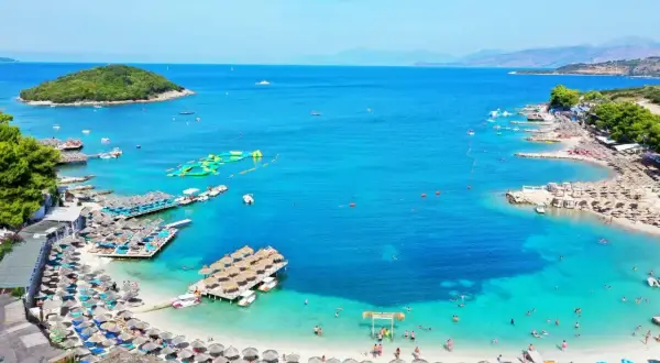 Rajskie albania plaże z turkusową wodą, leżakami i pływającymi atrakcjami. Idealne miejsce na wakacje.