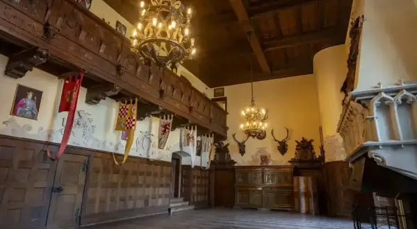 Wnętrze zamku Czocha zachwyca bogactwem detali. W sali balowej wiszą okazałe żyrandole, a na ścianach widnieją herby i trofea łowieckie. To jedne z wielu atrakcji zamku.