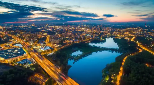 Zachód słońca nad miastem, gdzie autostrada przecina park z trzema stawami w Katowicach.