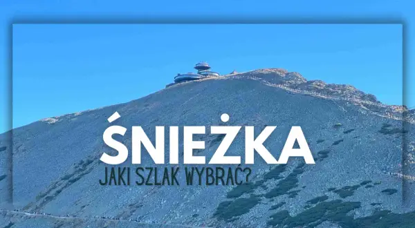 Szlak na Śnieżkę. Widok na górę z budynkami na szczycie i turystami na ścieżkach.