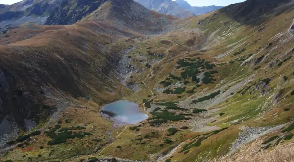 Malownicze Tatry oferują wspaniałe atrakcje. Widok na górskie jezioro i strome zbocza zachwyca.