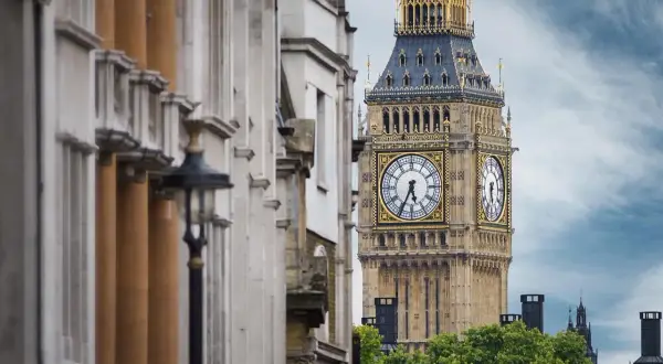 Big Ben, jedna z głównych atrakcji Anglii, góruje nad zielonymi drzewami. Obok widać zabytkową architekturę.