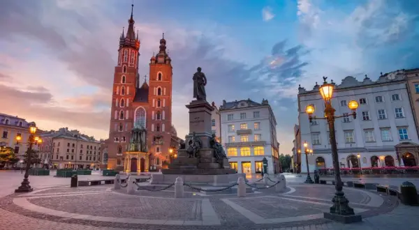 Zachód słońca na Rynku Głównym w Krakowie. Spacer po Rynku, zwiedzanie Sukiennic i Kościoła Mariackiego to tylko część tego, co można robić w Krakowie.