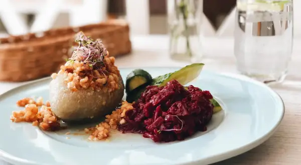 Pyszne cepeliny z buraczkami i ogórkiem, idealne na obiad w jednej z białostockich restauracji.