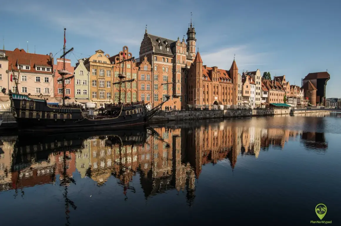 Gdańsk atrakcje: zabytkowy żaglowiec cumuje przy nabrzeżu Motławy, obok kolorowych kamieniczek.