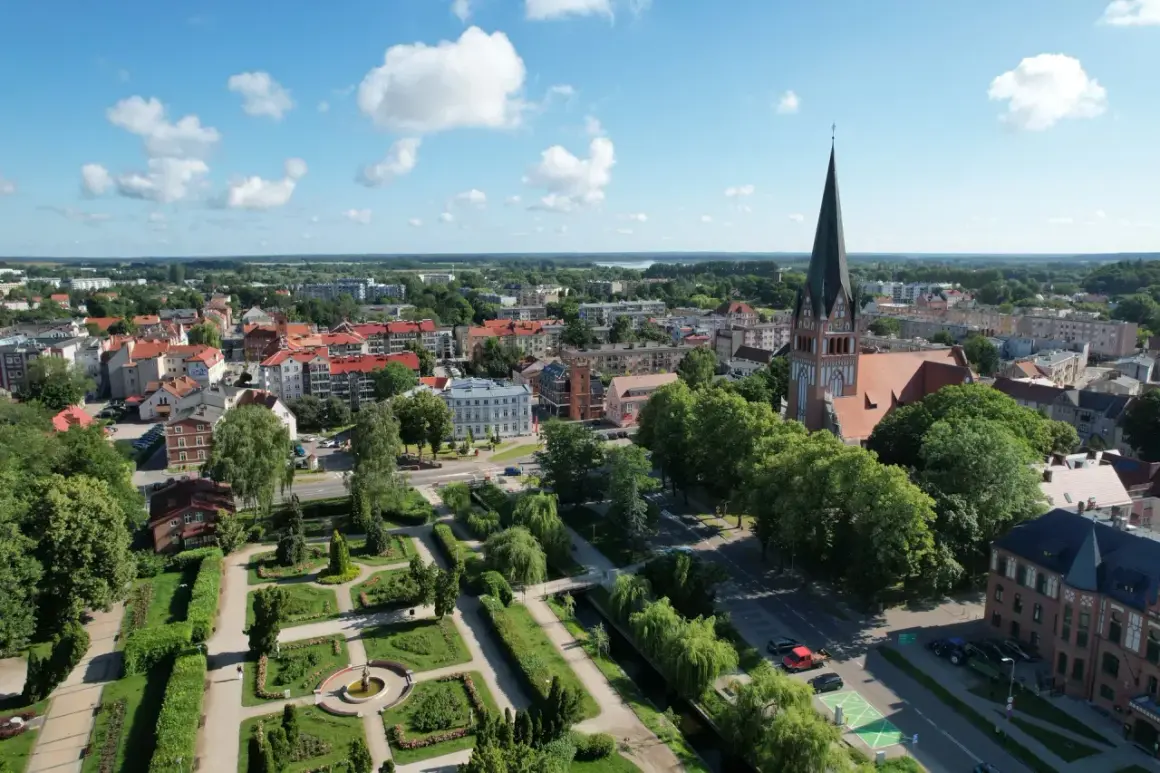Widok na miasto z lotu ptaka, z dominującą wieżą kościoła i zielonym parkiem. Szczecinek atrakcje zachęcają do spacerów.