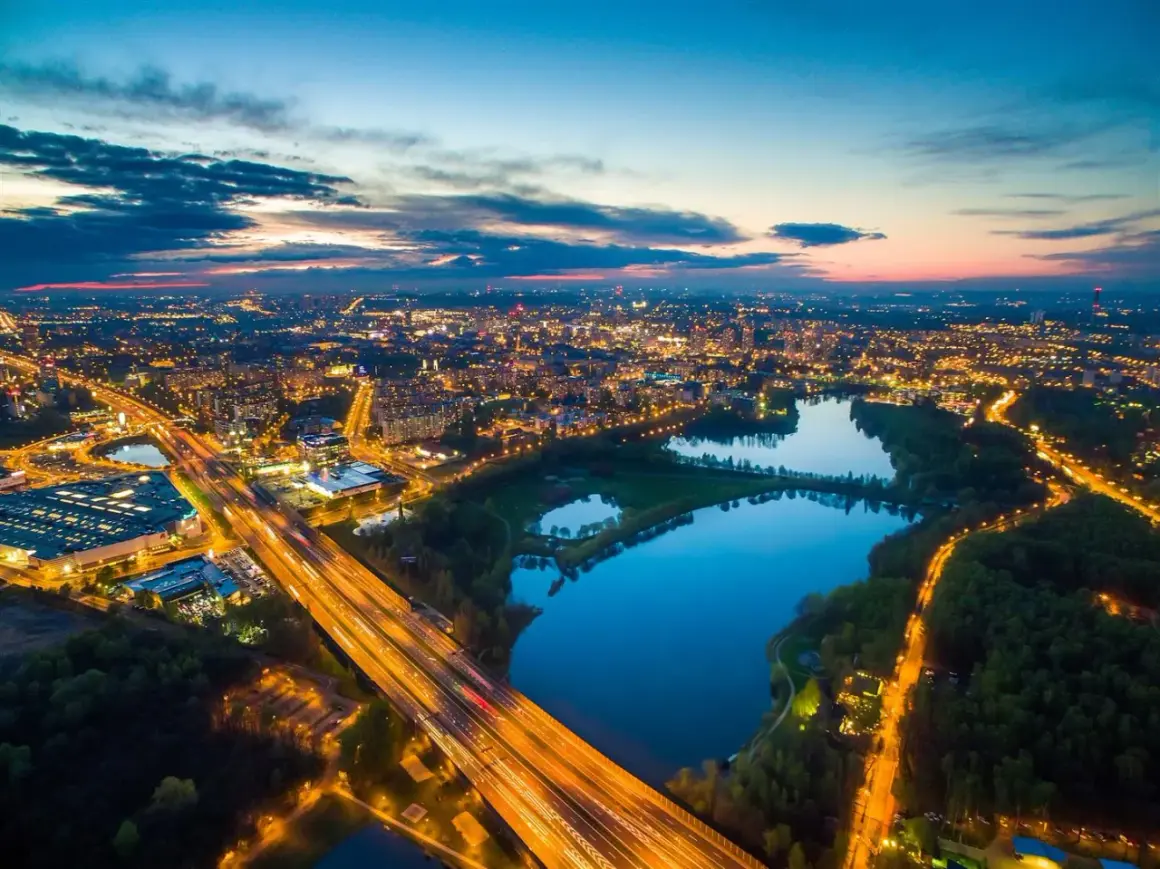 Zachód słońca nad miastem, gdzie autostrada przecina park z trzema stawami w Katowicach.