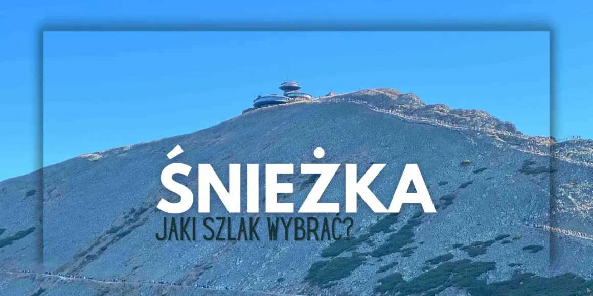 Szlak na Śnieżkę. Widok na górę z budynkami na szczycie i turystami na ścieżkach.
