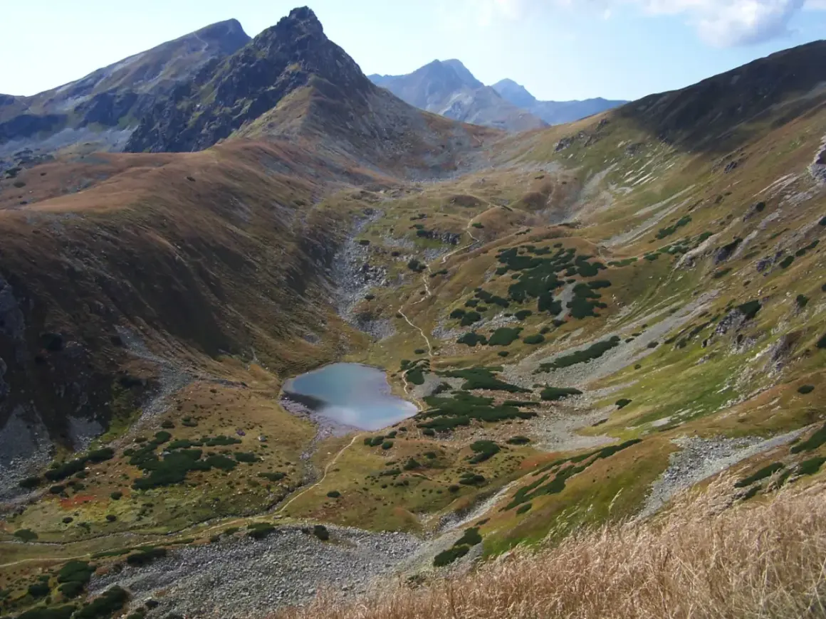 Malownicze Tatry oferują wspaniałe atrakcje. Widok na górskie jezioro i strome zbocza zachwyca.