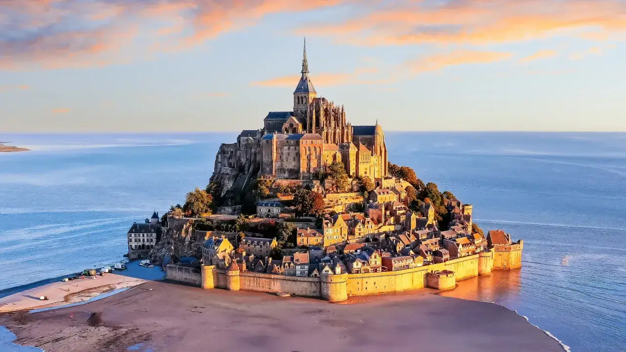 Mont Saint-Michel, jeden z najpiękniejszych zabytków Francji, majestatycznie wznosi się na wyspie otoczonej wodą.