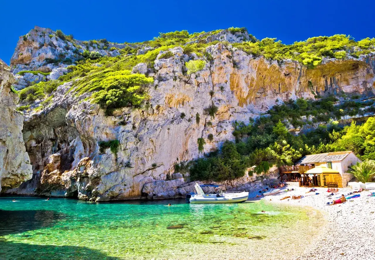 Malownicza zatoka z krystalicznie czystą wodą i kamienistą plażą. Idealne chorwackie plaże dla miłośnik&oacute;w słońca i spokoju.