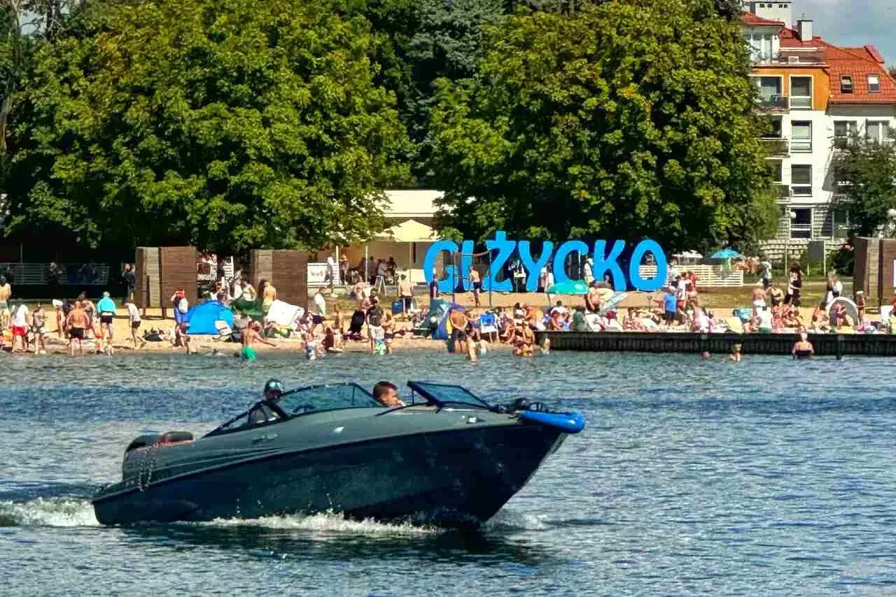 Motor&oacute;wka sunie po jeziorze, a na brzegu w Giżycku tętni życie. To idealne mazury atrakcje wodne dla każdego.