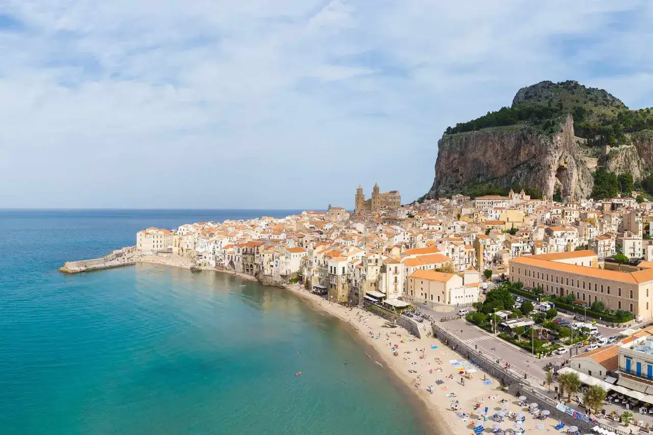 Cefal&ugrave;, Sycylia &ndash; jedno z najpiękniejszych plaż we Włoszech. Turkusowe morze, złoty piasek i urokliwe miasteczko pod skalistym klifem.