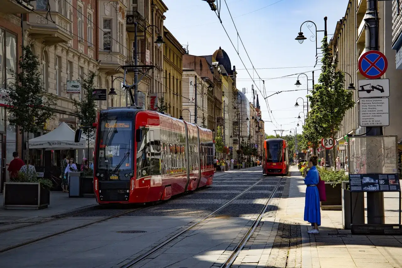Czerwone tramwaje na ulicach Katowic. Spacerując po mieście, można podziwiać architekturę i poczuć atmosferę miasta. Atrakcje w: Katowice czekają!